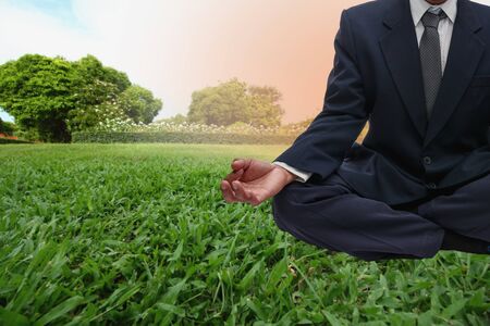 Businessman in suit practicing yoga in park  outdoor with natureの写真素材