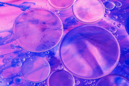 Oil and slough on water surface with pink blue backgroundの写真素材