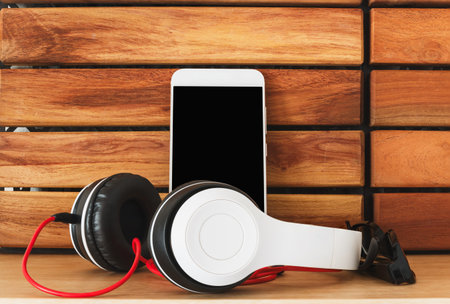 Headphones  and smartphone on wood floor background ,Concept listen to music