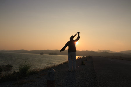 Landscape with a woman stand watching the morning sunrise in winter.