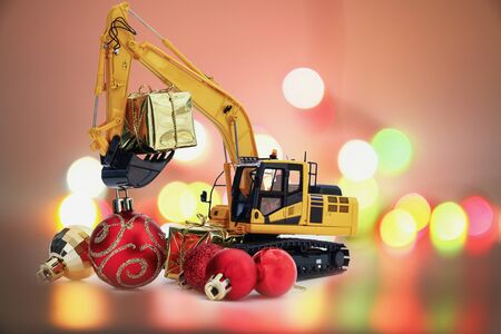 Christmas ornament and Gifts with Excavator model ,  Holiday celebration concept new year on bokeh backgroundの写真素材