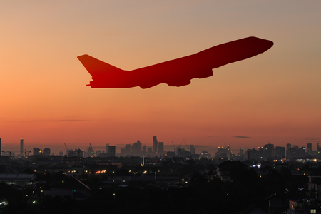 The silhouette of an airplane with a background of sunset light.の写真素材