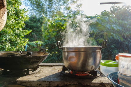Hot steam from a cooking pot on a gas stove in the kitchen.の写真素材