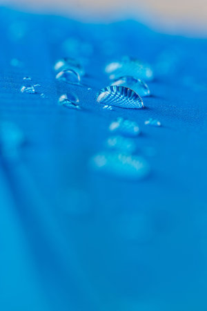 Rain water droplets on  blue waterproof fabric  background