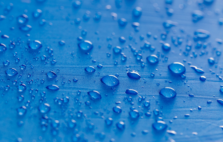Rain water droplets on  blue waterproof fabric  backgroundの写真素材