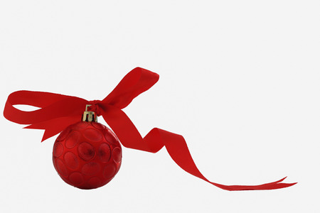 Christmas ornament red ball with ribbon on isolated whiteの写真素材