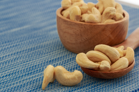 Cashew nuts in a wooden spoon with fabric  on tableの写真素材