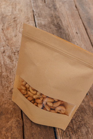The packaging bag with Cashew nuts on a floor woodenの写真素材