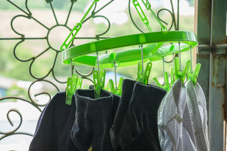 Green clothespin, socks clamp and white pants Dry clothes on the balconyの写真素材