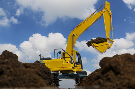 Excavators are digging the soil in the construction site on the blue sky background