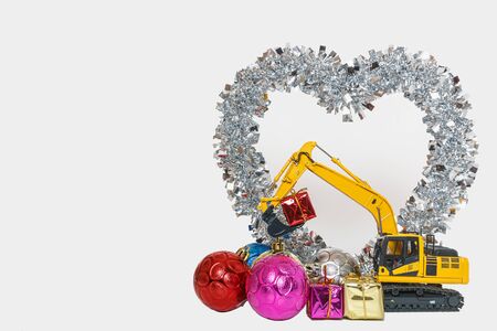 Christmas ornament with Excavator model,  Holiday celebration concept new year on shape heart whiteの写真素材