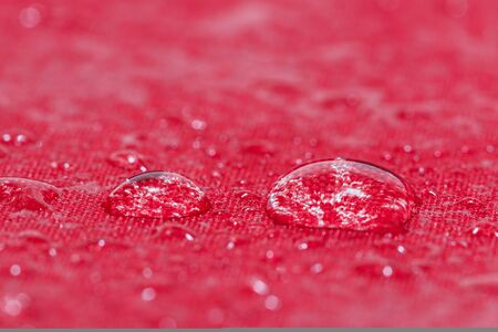 Water droplets on  a  red waterproof fabric backgroundの写真素材