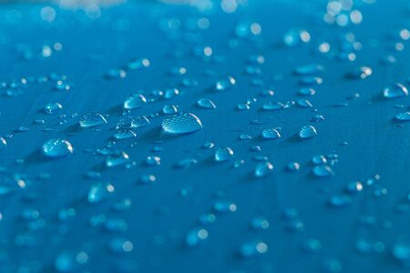 Water droplets on a  waterproof fabric blue backgroundの写真素材