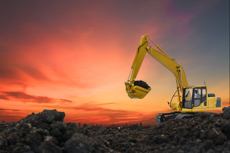 Excavators are digging the soil in the construction site on the orange  sky