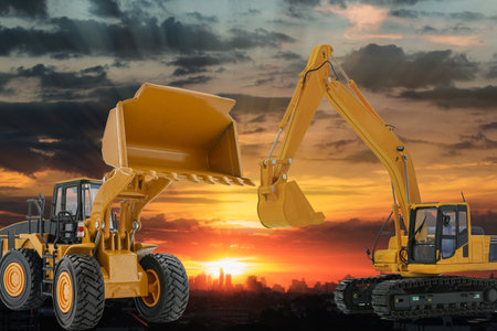 Excavators and wheel loader  in the construction site on the sunset backgroundの写真素材