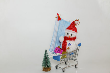 Christmas decoration with medical face masks lie in a shopping trolley,Concept of choosing  and buying  new year festival in safetyの写真素材