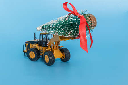 Christmas tree with  wheel loader model lift up.  Festival holiday celebration conceptの写真素材
