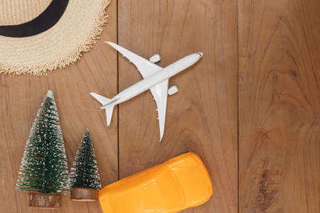 Flat lay  composition hat with Christmas tree and  airplane model ,toy car on wooden background .Holiday travel conceptの写真素材
