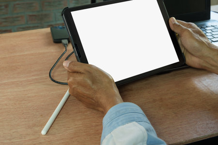 Digital tablet white blank screen display in  male hands on table  work form home