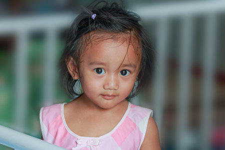Portrait of asian baby girl toddler, Face looking glancing at camera with a smile in home