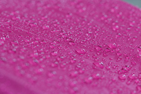 Water droplets on a magentas waterproof fabric  background,close upの写真素材