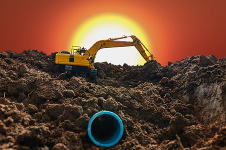 Crawler excavator is digging in the construction site pipeline work on sunset  backgroundの写真素材