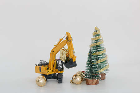 Excavator model with  Christmas ornament ,  Holiday celebration concept new year on white backgroundの写真素材