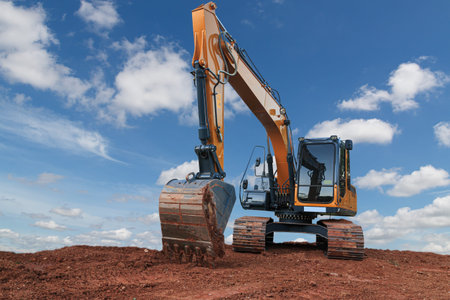 Yellow excavators are digging the soil in the construction site on the cloud and  sky  background