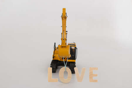Concept love valentine day ,excavator of lift up bucket that is installing the  letters O ,on white background.の写真素材