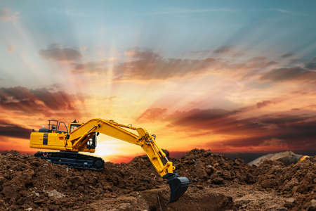 Excavators  are digging soil with  in the construction site on sunbeam  backgroundの写真素材