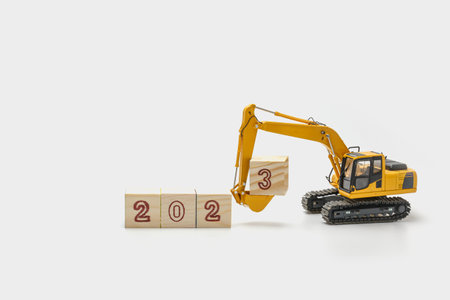 Concept Happy new year 2023,Crawler excavator with bucket lift up that is installing the numbers three on white backgroundsの写真素材