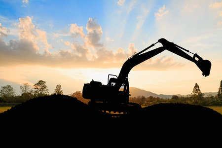 Crawler excavator  digging soil at construction site and lift up bucket on  sunset backgrounds.