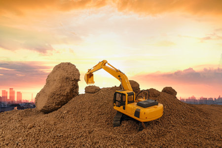 Crawler excavator is digging soil in the construction site with orange sky backgrounds.の写真素材