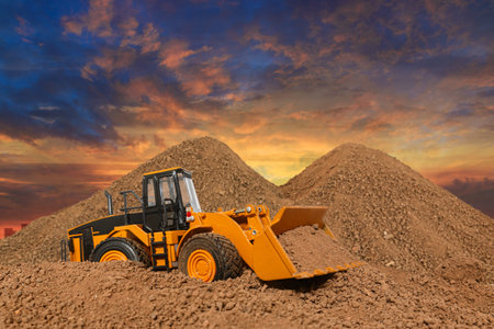 Wheel loader are digging the soil in construction site  ,With on  cloud and sky  background.