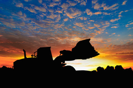 Wheel loader  silhouette are digging the soil in the construction site.With on  cloud and sky  background.の写真素材
