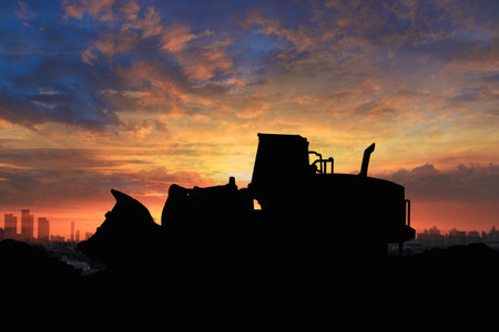 Wheel loader  silhouette are digging the soil in the construction site.With on  cloud and sky ...
