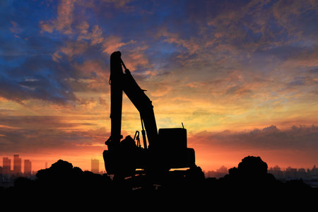 Crawler excavators silhouette are digging the soil in the construction site citys. on sunset...