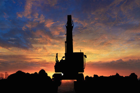 Silhouette of excavator loader  in the construction site on the sky sunset  background