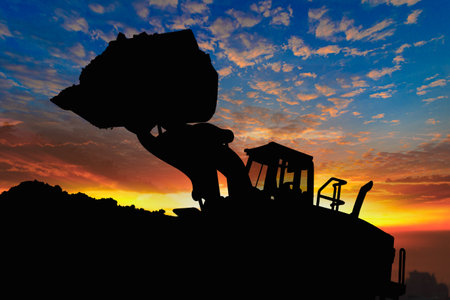 Wheel loader silhouette are digging the soil in the construction site on the  sunset sky backgroundの写真素材