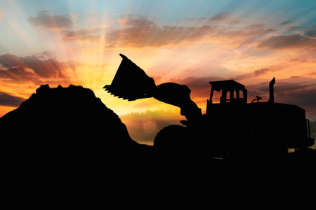 Wheel loader black silhouette  on a sunset backgroundの写真素材