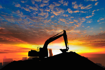 Crawler excavators silhouette are digging the soil in the construction site. on  sunset backgroundの写真素材