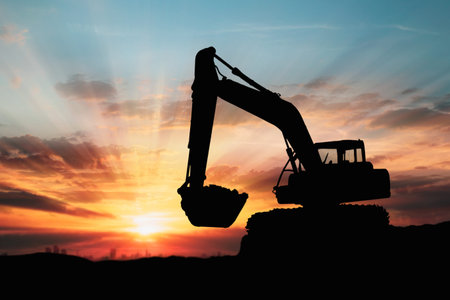 Crawler excavators silhouette are digging the soil in the construction site. With blue sky and...