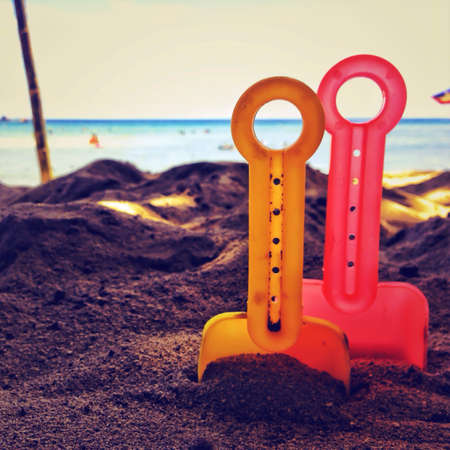 toy spades in the sandの素材