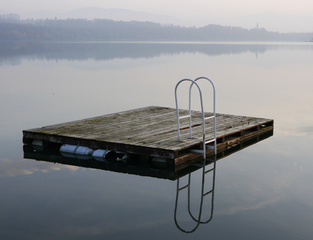 Swimming pier after season reflected on the surface of the dam. Northern Moravia.の写真素材