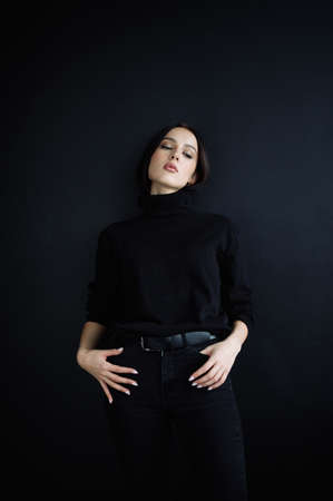 Elegant series of photos of young fantastic model. studio. European type, handsome lips, beautiful eyes. Black background. black clothes. Emotional. minimalism. style. Good for cosmetics advertisingの写真素材