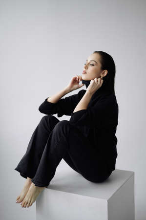 Good series of photos of young pretty woman. studio. European type, big lips, awesome eyes, slim body. white background. black clothes. Emotional. minimalism. style. fashionable and modern lifestyleの写真素材