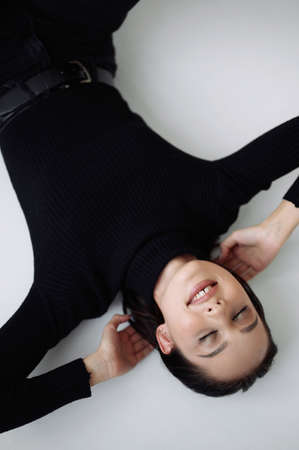 Good series of photos of young pretty woman. studio. European type, big lips, awesome eyes, slim body. white background. black clothes. Emotional. minimalism. style. fashionable and modern lifestyleの写真素材
