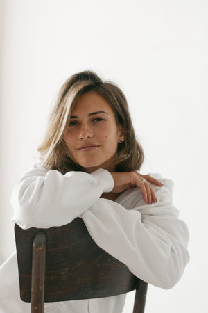 Portrait of beautiful young woman with brown hair and clean bronze skin without makeup on white...