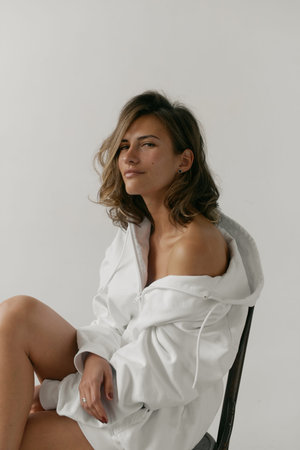 Portrait of beautiful young woman with brown hair and clean bronze skin without makeup on white...