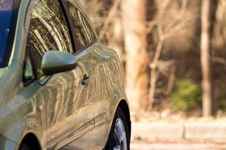 Ecologilcal car. Totally fits in a forest landscape. Reflection of the trees is all over the body and windows of the vehicle.の写真素材
